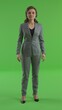 © Thanaporn - Cute female presenter, full body photo in a gray suit Contrasting with the green screen background
