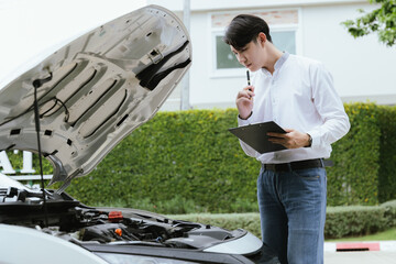 Wall Mural - A male mechanic inspects a broken-down car on the roadside, while a female insurance agent provides assistance. The Caucasian driver, holding a clipboard, discusses the damage and files a claim for re