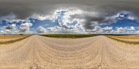 Wall Mural - spherical 360 hdri panorama on side of gravel road with rain storm clouds in dark sky in equirectang