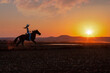 © poco_bw - silhouette cowgirl in the sunset riding galloping in the prairie near a waterhole