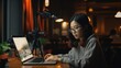 © Aliando - Young woman working on her laptop in a cafe