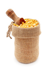 Wall Mural - Close-up of Organic Bengal Gram (Cicer arietinum) or split yellow chana dal, in a jute bag with a scoop, Isolated on a white background.