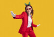 © Studio Romantic - Happy joyful smiling beautiful young woman wearing red suit, white gloves, sunglasses and funny Christmas headband having fun and dancing isolated on yellow background. Xmas, holiday, party concept
