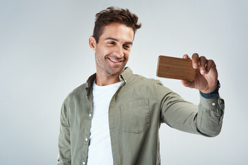 Poster - Fashion, selfie and smile with man in studio on white background for post or status update. App, mobile and photograph with happy influencer person in casual outfit for social media profile picture