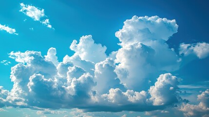 Poster - Puffy white clouds float lazily in a clear blue sky, illuminated by the vibrant sunlight of a warm afternoon