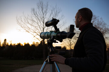 Wall Mural - amateur astronomer observing sun eclipse and sun with a telescope and special solar filter.