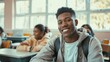 © VK Studio - A high school student with a broad smile, sitting in a classroom with peers blurred in the background, showcasing a lively learning environment.