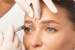 © Home-stock - Beautiful young woman getting cosmetic injection between eyebrows, beautician making injection for glabella facial rejuvenation procedure, closeup