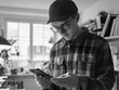 © Alexander Chaykin - A person examining their mobile device, wearing a hat and glasses