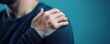 © Kunalai - Close-up of hand gripping shoulder in agony, pain, acute discomfort