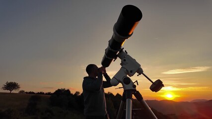 Wall Mural - Amateur astronomer looking at the evening skies, observing planets, stars, Moon and other celestial objects with a telescope just before sun down.	
