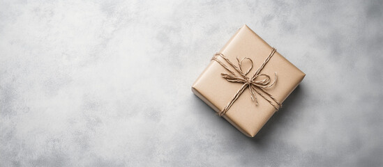 Wall Mural - A box in Brown gift wrapping paper on a gray concrete background, an empty space for text, flat lay.