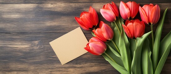 Poster - Fresh tulips and a greeting card on a wooden table background. with copy space image. Place for adding text or design