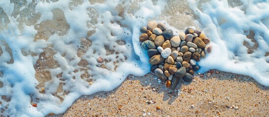 Wall Mural - Heart shaped sea pebbles on a sandy beach A symbol of love or a romantic holiday concept Top view and copy space