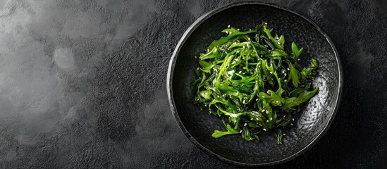 Poster - Seaweed salad served on a black stone plate Chinese cuisine Top view Free copyspace