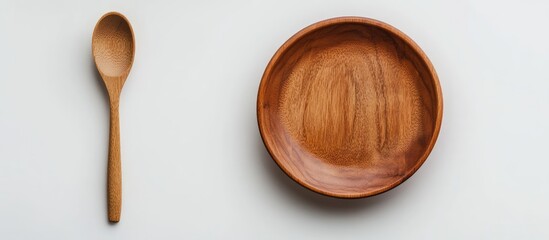Poster - An empty wooden spoon and plate on a white background featuring wooden dishware and tableware. with copy space image. Place for adding text or design