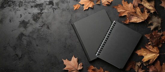 two notebooks and dried leaves on a surface. with copy space image. Place for adding text or design