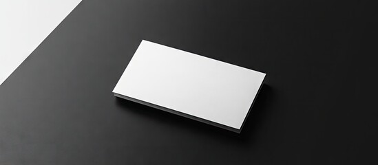 Leinwandbilder - White blank business visit card gift ticket pass or present positioned closely against a black and white background Copy space for a blank corporate identity package business card template for ID