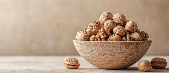 Fototapete - Bowl of large organic walnuts with a beige background. with copy space image. Place for adding text or design