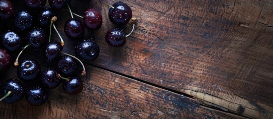 Wall Mural - Close up of fresh black cherries on a wooden surface. with copy space image. Place for adding text or design