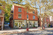 © alpegor - Traditional American brick buildings with shops on ground floor along a tree lined street in a historic downtown on a sunny autumn day