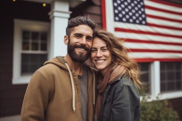 Wall Mural - Portrait of a smiling young American couple in front of house