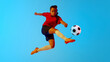 © Lustre Art Group  - Female soccer player mid-flight, striking ball with precision and power in neon light against colorful gradient background. Concept of women and sport, team games, movement, victory, action. Ad
