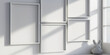 © AMA STUDIO - White empty frames hanging on a white wall in a sunny room with a toy rabbit