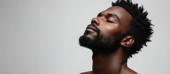 Poster - An appealing Afro American man is posing in a studio against an isolated background. with copy space image. Place for adding text or design