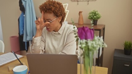 Sticker - Insulting with style, laughing african-american woman sits at home, fingers crafting 'loser' gesture on forehead, mocking others