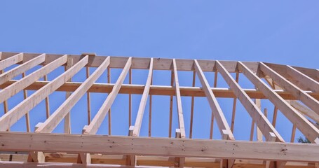 Wall Mural - Wooden roofing truss frame is installed by house under construction roof