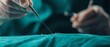 © ธนากร บัวพรหม - Close-up of a surgeon performing a delicate stitch on green fabric during a medical procedure in a sterile environment.
