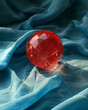 © Altura - Composition with a red gem sphere on a blue draped fabric background. Generative AI.