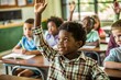 © Volodymyr - A black boy in the classroom raises his hand to answer during the lesson