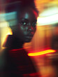 © AdPremium - Motion blur portrait of a beautiful young black woman looking at the camera. Generative AI.