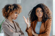 © Altura - Two African American businesswomen discussing in the workplace. Generative AI.
