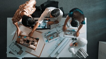 Poster - Top view of project manager working together to brainstorm house design while standing around meeting table with project plan and blueprint. Aerial view of designer team explain project. Alimentation.