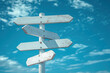 © BOTAHRY DEX - Image of five blank white road signs pointing in different directions against a bright blue sky with scattered clouds.