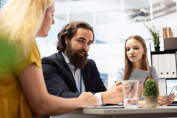 Financial advisor helping family members in office, offering economic services such as analyzing financial markets, developing investing strategies and monitoring stock market portfolio