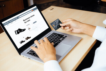 Young man use credit card for shopping payment online on laptop computer application or website. E-commerce and online shopping concept. uds