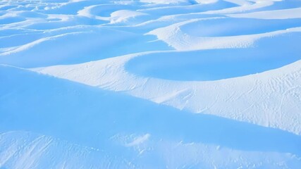 Poster - The smooth symmetrical patterns of snow drifts are highlighted in this closeup showcasing the harmonious dance between wind and snow.