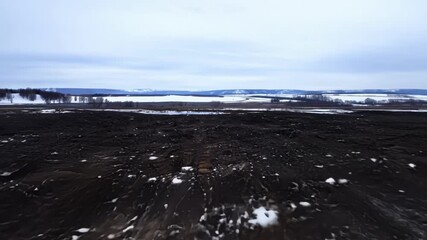 Poster - A timelapse of a snowy landscape transforming into a wet muddy terrain as the snow melts away.