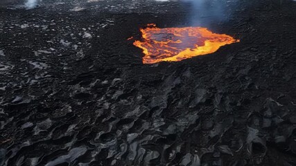 Aufkleber - Sharp jagged lines of black and grey lava crisscross over a field of hardened lava creating a stark contrast of colors and textures as the molten lava continues to flow and bubble.