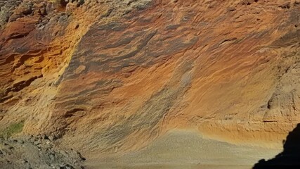 Aufkleber - A closeup of a weathered cliff shows a kaleidoscope of colors and unique patterns created by layers of sediment and erosion.