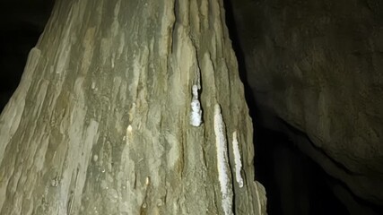 Poster - A closeup shot of a large stalagmite with its pointed tip reaching towards the ceiling of the cave revealing the slow and steady process of mineral formation.