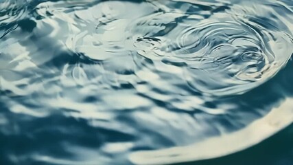 Aufkleber - The camera zooms in to reveal the intricate patterns formed by the constantly shifting ripples on the waters surface.