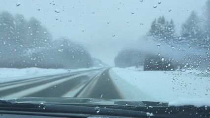 Poster - A slowmotion shot of a persons hand gently brushing away the powdery snow on a cars windshield.