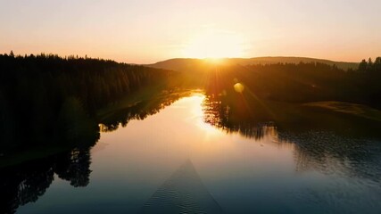 Aufkleber - The suns reflection dances across the surface of a tranquil lake as it sinks lower in the sky signaling the end of another day.