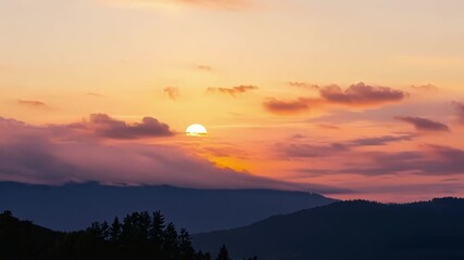 Aufkleber - Wispy clouds are painted in shades of pink and gold as the sun sets behind a distant mountain range signaling the end of another day.