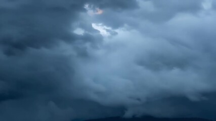 Poster - A closeup shot of dark grey storm clouds rolling and cascading over one another.